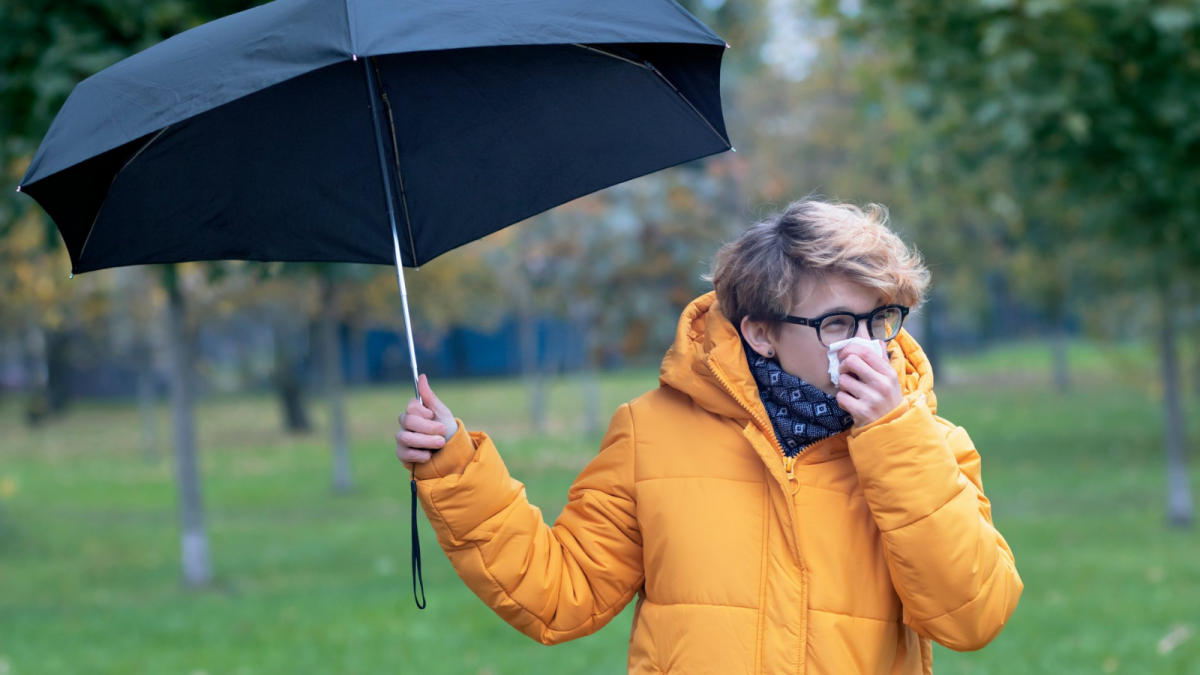 Frau im Park mit Schirm und Taschentuch